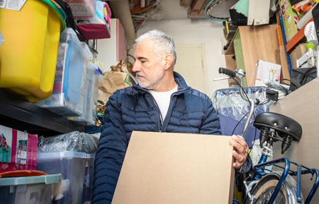 Man moving junk from his garage
